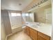 Bright bathroom with a bathtub, shower and wood cabinets at 8760 Harvest Valley Ave, Las Vegas, NV 89129