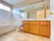 Clean bathroom, wood cabinets, bathtub and shower at 8760 Harvest Valley Ave, Las Vegas, NV 89129