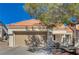 Single-story home with a tan garage door and Spanish tile roof at 9320 Quail Ridge Dr, Las Vegas, NV 89134