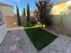 Landscaped backyard with artificial turf and stone pathway at 9332 Newbattle St, Las Vegas, NV 89178