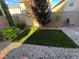 Artificial turf backyard with gravel border and a small tree at 9332 Newbattle St, Las Vegas, NV 89178