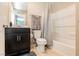 Clean bathroom with dark vanity, shower/tub combo, and gray floor at 9332 Newbattle St, Las Vegas, NV 89178