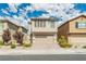 Two-story house with beige siding, brown shutters, and a paved driveway at 9332 Newbattle St, Las Vegas, NV 89178