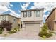 Two-story home featuring beige stucco, brown shutters, desert landscaping and a two-car garage at 9332 Newbattle St, Las Vegas, NV 89178