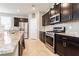 Modern kitchen with dark cabinetry, granite countertops, and stainless steel appliances at 9332 Newbattle St, Las Vegas, NV 89178