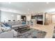 Open-concept living room flows to kitchen with dark cabinets and island seating with a modern blue area rug at 9332 Newbattle St, Las Vegas, NV 89178