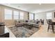 Living room with gray sectional sofa, tile floor, and dining area at 9332 Newbattle St, Las Vegas, NV 89178