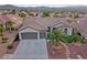 Single-story home with three-car garage, palm tree and landscaping at 1999 Oliver Springs St, Henderson, NV 89052