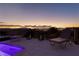 Evening view of a pool deck with lounge chairs and city lights at 1999 Oliver Springs St, Henderson, NV 89052