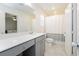 Bright bathroom with sleek countertops, modern fixtures, and a shower-tub combo; Bedroom in the mirror at 2499 Adige Pl, Henderson, NV 89044