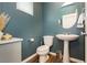 Stylish powder room with pedestal sink, round mirror, and modern fixtures at 2499 Adige Pl, Henderson, NV 89044