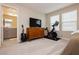 This bedroom has two large windows, an exercise bike, a guitar, and a view to the bathroom at 2499 Adige Pl, Henderson, NV 89044