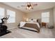 Well-lit bedroom with a ceiling fan, soft carpet, and modern decor at 2499 Adige Pl, Henderson, NV 89044