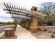 Scenic community walkway featuring decorative trellises, mature landscaping, and manicured planters along a paved path at 2499 Adige Pl, Henderson, NV 89044