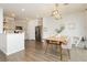 Open-concept dining room and kitchen area with stainless steel refrigerator and modern pendant lighting at 2499 Adige Pl, Henderson, NV 89044