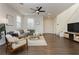 Open living room with hardwood floors, gray sectional sofa, and a ceiling fan at 2499 Adige Pl, Henderson, NV 89044