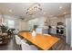 Open-concept living space featuring a modern light fixture, staircase, and stainless steel appliances at 2499 Adige Pl, Henderson, NV 89044