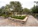 Beautiful park featuring stone planters, mature trees, shaded seating, and brick paver walkways in a tranquil setting at 2499 Adige Pl, Henderson, NV 89044