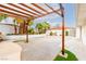 Large backyard featuring wood pergola, palm trees and manicured landscaping at 3127 S Eastern Ave, Las Vegas, NV 89169