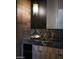 Modern powder room features a decorative light fixture and a wood and marbled countertop at 4377 Cameron Brook Ct, Las Vegas, NV 89129