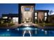 Modern home exterior featuring a pool and reflecting pool with a courtyard entrance and a well-lit exterior at 4377 Cameron Brook Ct, Las Vegas, NV 89129