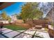 Landscaped backyard with artificial turf, fire pit, and sitting walls at 5023 Tunnel Falls Dr, Las Vegas, NV 89141