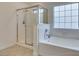 Bathroom featuring a soaking tub and glass-enclosed shower, complemented by natural light at 5416 Lochmor Ave, Las Vegas, NV 89130