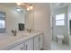 Bathroom featuring dual sinks, white cabinetry, and modern fixtures under bright vanity lighting at 5416 Lochmor Ave, Las Vegas, NV 89130