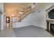 Open-concept living room with staircase, fireplace, neutral carpet, and high ceilings for a spacious feel at 5416 Lochmor Ave, Las Vegas, NV 89130