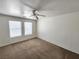 Bedroom with two windows, carpet, and ceiling fan at 6104 Daisy Lee Ave, Las Vegas, NV 89108