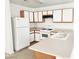 Galley kitchen with light wood cabinets and white appliances at 6104 Daisy Lee Ave, Las Vegas, NV 89108