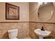 Small bathroom with beige tile, pedestal sink, and framed art at 6203 Sun Seed Ct, North Las Vegas, NV 89081