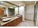 Elegant bathroom with dual sinks, granite countertops, and a walk-in shower at 7045 Edna Ave, Las Vegas, NV 89117