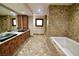 Elegant bathroom with double sinks, soaking tub, and tile flooring at 7045 Edna Ave, Las Vegas, NV 89117