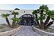 Elegant home entrance with palm trees and a unique arched gate at 7045 Edna Ave, Las Vegas, NV 89117