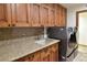 Laundry room with wood cabinets, granite countertop, and LG appliances at 7045 Edna Ave, Las Vegas, NV 89117