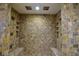 Large walk-in shower with built-in seating and stone tile at 7045 Edna Ave, Las Vegas, NV 89117