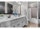 Bathroom featuring double sinks, white cabinetry, a mirror, and a shower-tub combination at 7520 Darian Jane St, Las Vegas, NV 89149