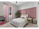 Sweet bedroom showcasing a pink accent wall, plush decor, and soft lighting for a cozy and inviting atmosphere at 7520 Darian Jane St, Las Vegas, NV 89149
