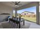 Covered patio with ceiling fan, dining table and chairs with a view of the grassy backyard at 7520 Darian Jane St, Las Vegas, NV 89149