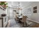 Spacious dining area featuring a large table, stylish chandelier, plantation shutters, and elegant decor at 7520 Darian Jane St, Las Vegas, NV 89149