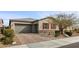 Charming single-story home featuring a two-car garage, brick driveway, stone accents, and inviting red shutters at 7520 Darian Jane St, Las Vegas, NV 89149