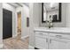 Hallway featuring a black door, wood-look floors, a marble countertop with cabinets, and decorative accents at 7520 Darian Jane St, Las Vegas, NV 89149