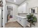 Hallway featuring white cabinets and drawers with black pulls, wood-look floors, and modern decor at 7520 Darian Jane St, Las Vegas, NV 89149