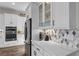 Bright kitchen featuring white cabinets, stainless steel appliances, decorative backsplash, and quartz countertops at 7520 Darian Jane St, Las Vegas, NV 89149