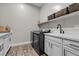 Laundry room featuring a sink, cabinets, modern washer and dryer, and a neutral color scheme at 7520 Darian Jane St, Las Vegas, NV 89149