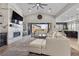 Inviting living room with a fireplace, large TV, hardwood flooring, and an open layout leading to the kitchen at 7520 Darian Jane St, Las Vegas, NV 89149