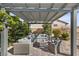 Inviting outdoor living space features a fire pit and comfortable seating under a pergola at 7520 Darian Jane St, Las Vegas, NV 89149