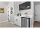Stylish wet bar with white cabinetry, stainless steel mini-fridge, and modern fixtures at 7520 Darian Jane St, Las Vegas, NV 89149