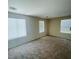 Spacious bedroom with neutral colored carpet and multiple windows at 9540 Birch Basin Ct, Las Vegas, NV 89148